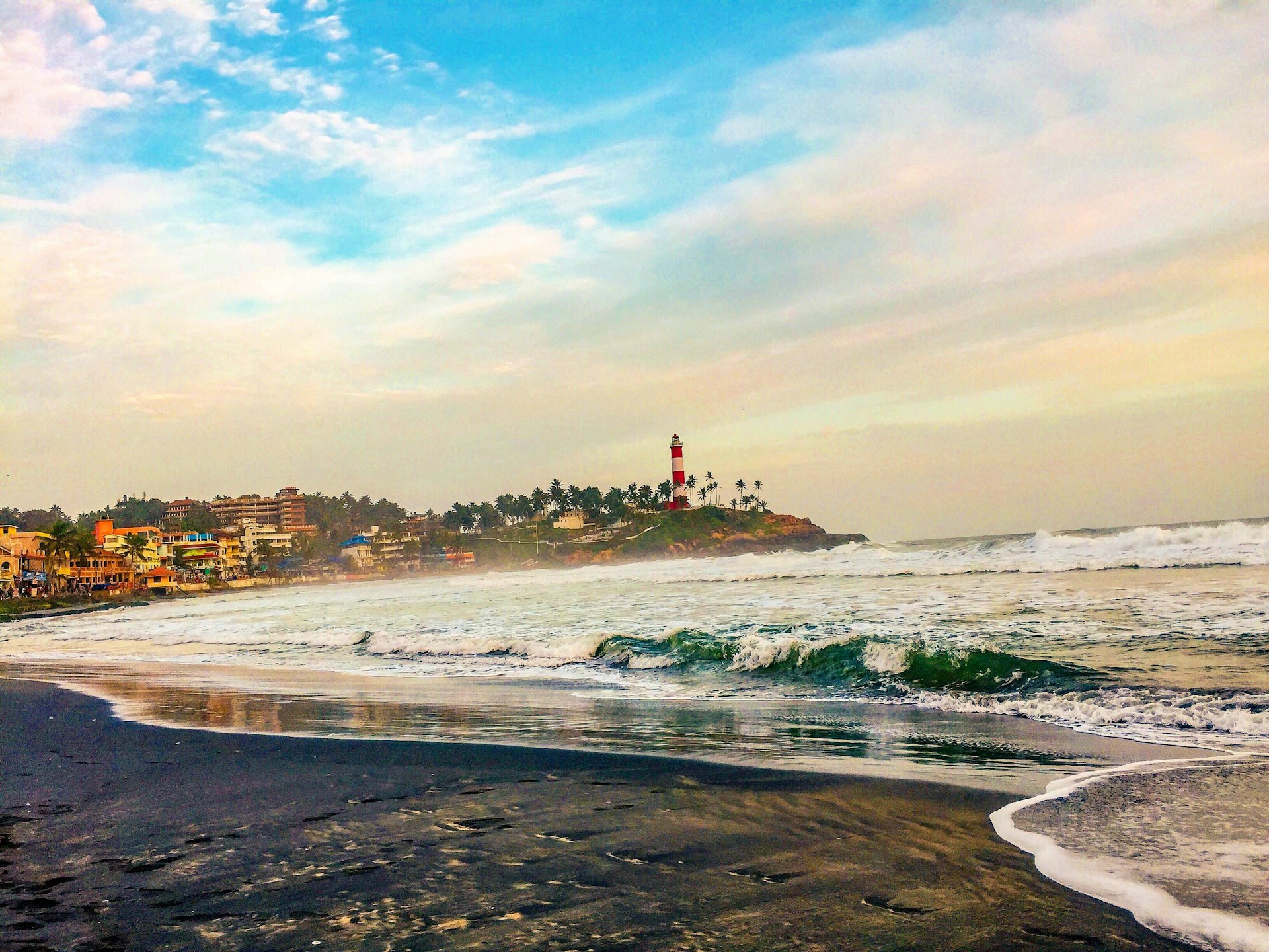 a view of a beach with a lighthouse in the distance